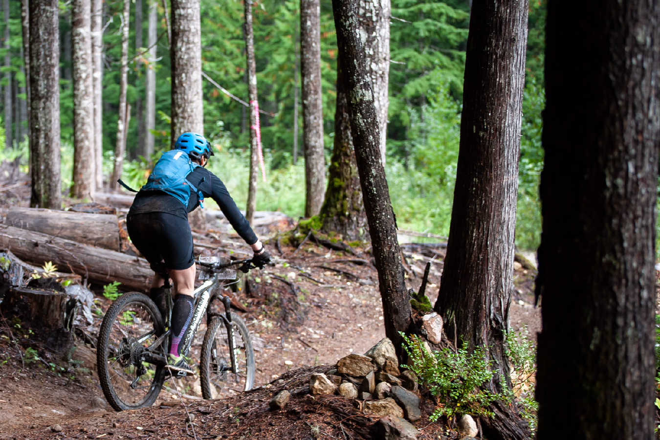 Women biking through woods who was helped with athletic therapy